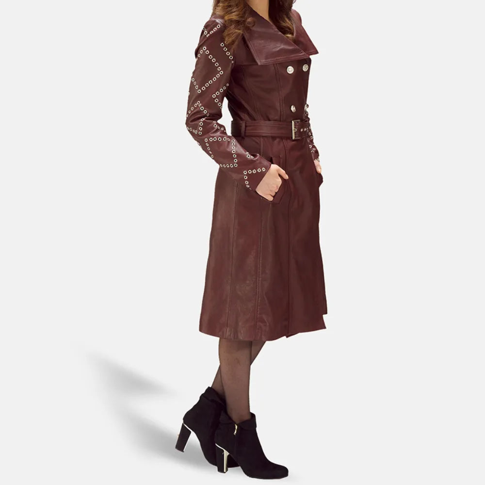 A stylish woman wearing a maroon leather trench coat, looking confident and fashionable.