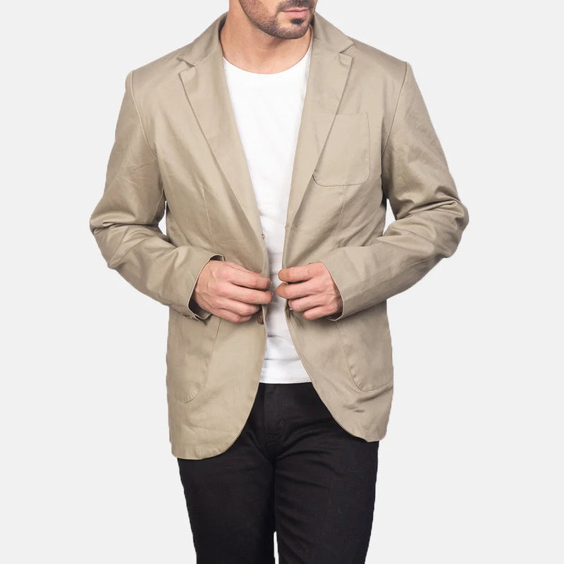 A well-dressed man in a beige cotton blazer jacket, radiating elegance and charm.