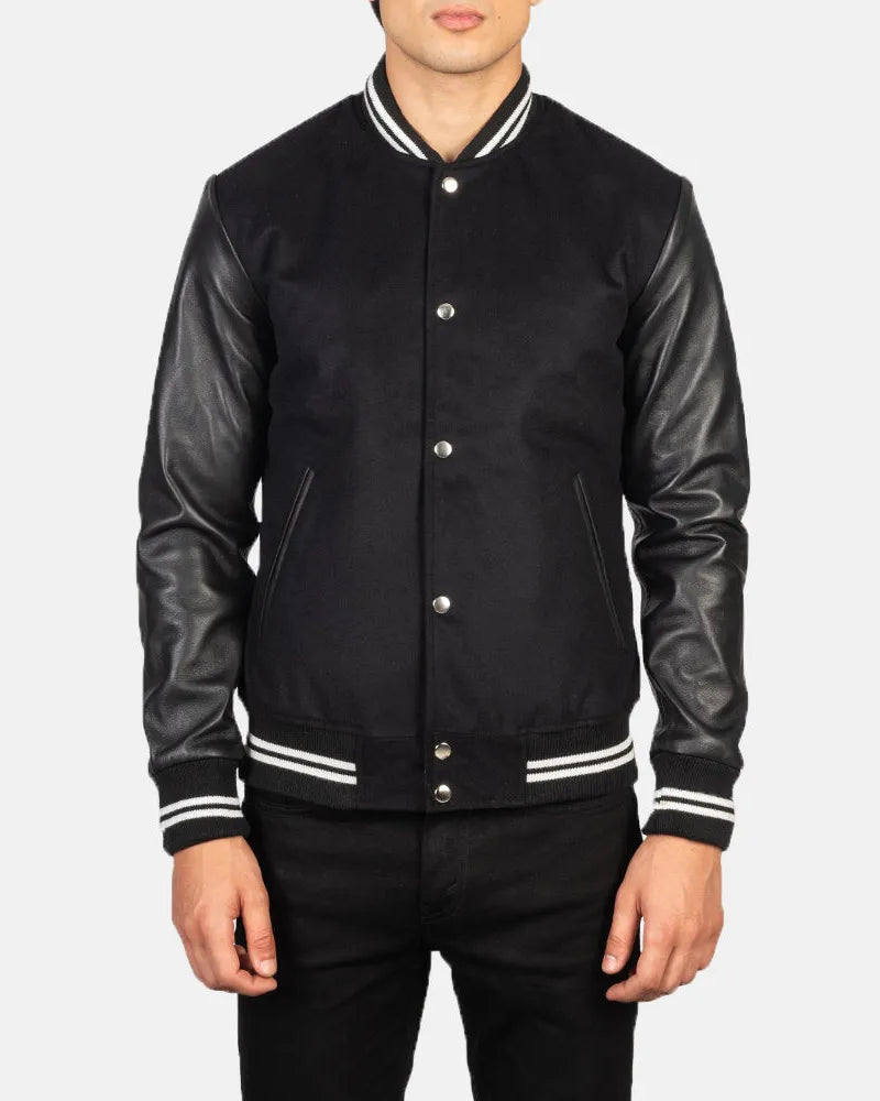 A fashionable black varsity jacket that combines a classic look with edgy leather sleeves.