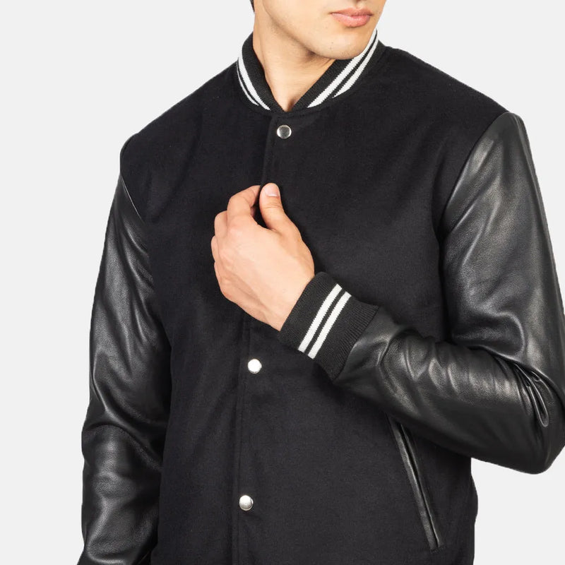 A fashionable black varsity jacket that combines a classic look with edgy leather sleeves.