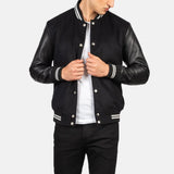 A fashionable black varsity jacket that combines a classic look with edgy leather sleeves.