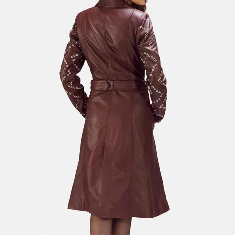 A stylish woman wearing a maroon leather trench coat, looking confident and fashionable.