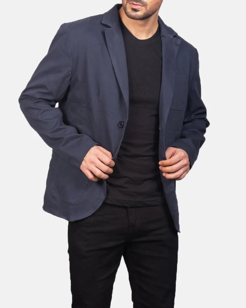 A stylish man wearing a navy blue leather blazer and black pants, exuding confidence and sophistication.