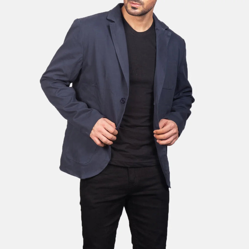 A stylish man wearing a navy blue leather blazer and black pants, exuding confidence and sophistication.